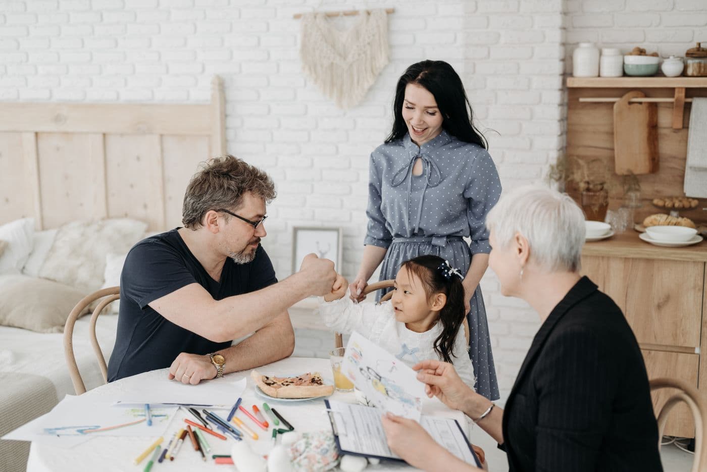 A social worker reviewing paperwork with foster parents and a child at home